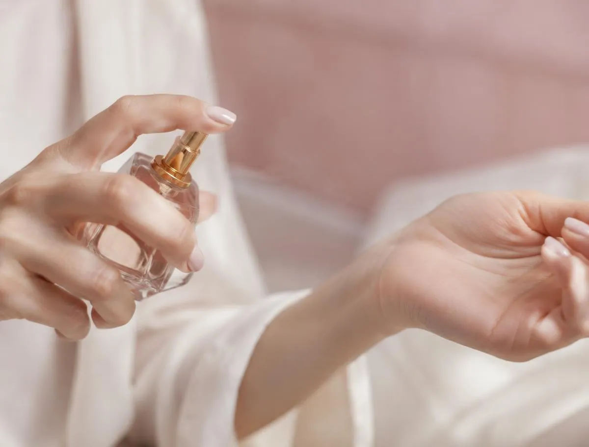 Mujer aplicándose perfume en la parte interna de la muñeca